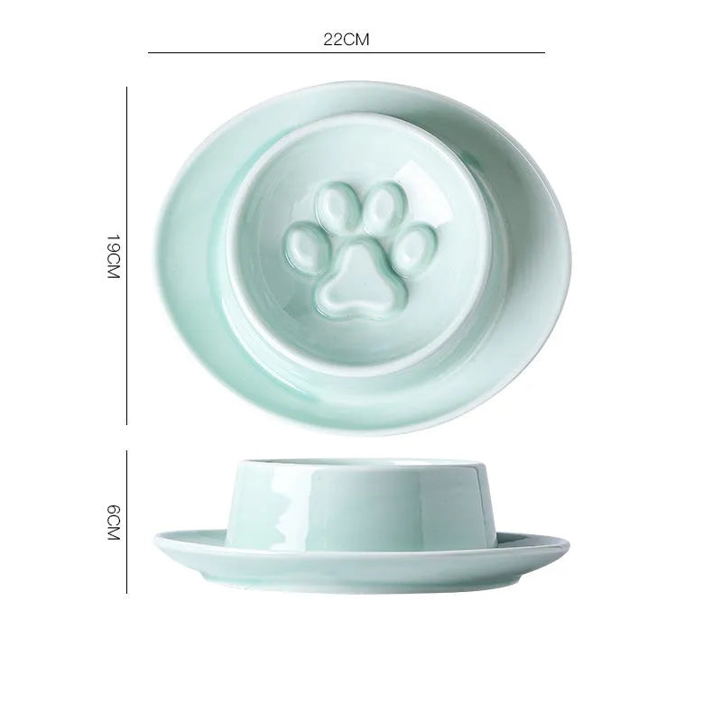 Green ceramic slow feed pet bowl with internal ridges and a raised centre on a white surface.