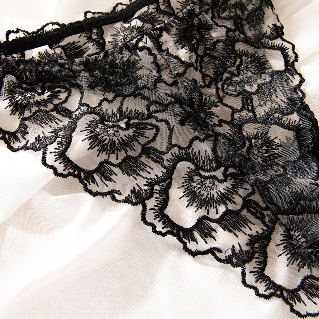 Black women's embroidered lace bikini set with steel ring accents on sheer polyester fabric