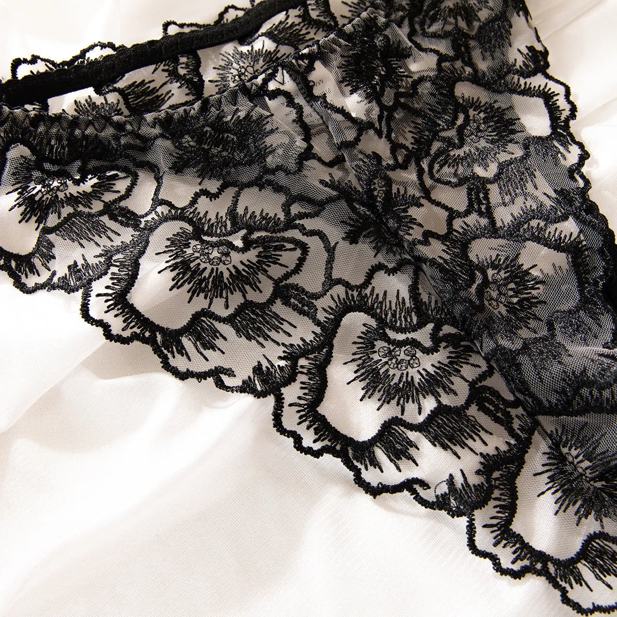 Black women's embroidered lace bikini set with steel ring accents on sheer polyester fabric