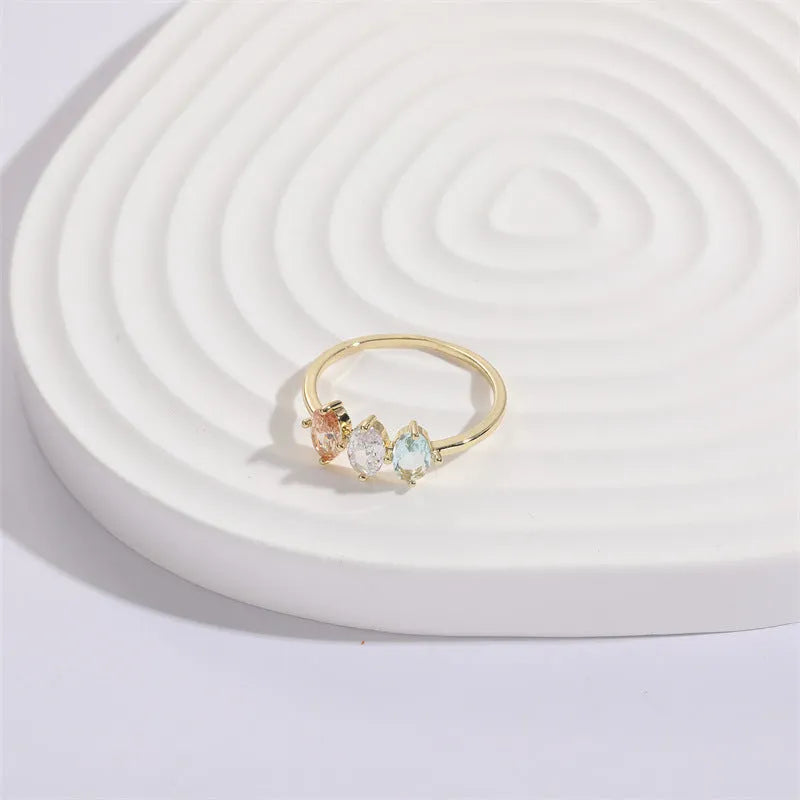 Geometric gold-colour women's ring with a triangular horse eye tricolour zircon stone.