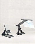 Black foldable mobile phone screen amplifier with detachable holder on a desk