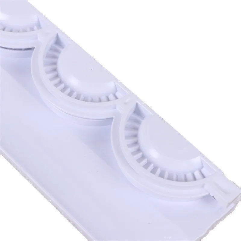 Pure white ABS plastic dumpling mould on a countertop, showing the mould shape for pressing dumplings