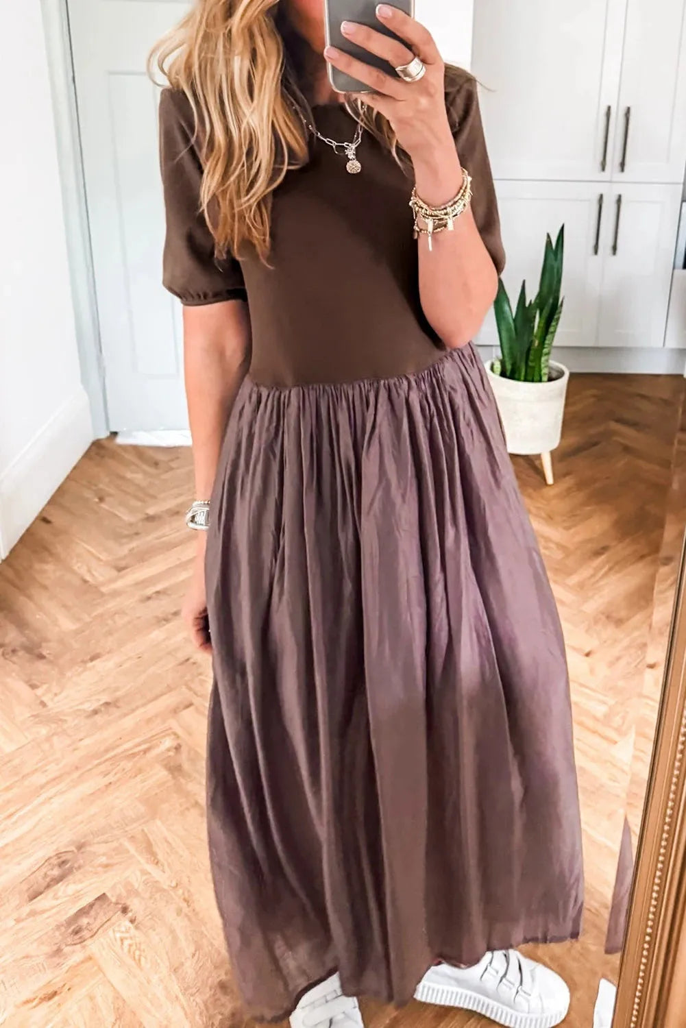 Woman wearing a coffee-coloured knitted patchwork dress with high waist and short sleeves