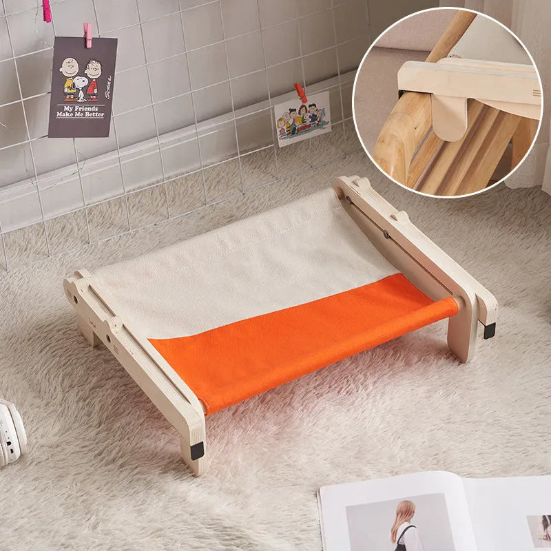Solid wood cat bed with a removable plaid cushion on a wooden frame.