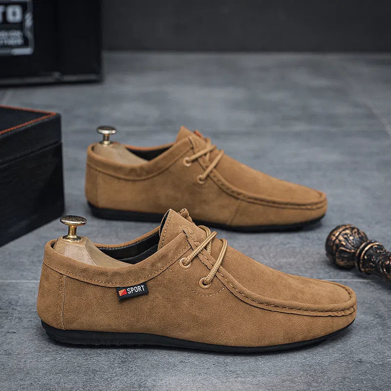 Men's black slip-on loafers with soft sole, round toe, and stitching detail on a neutral background