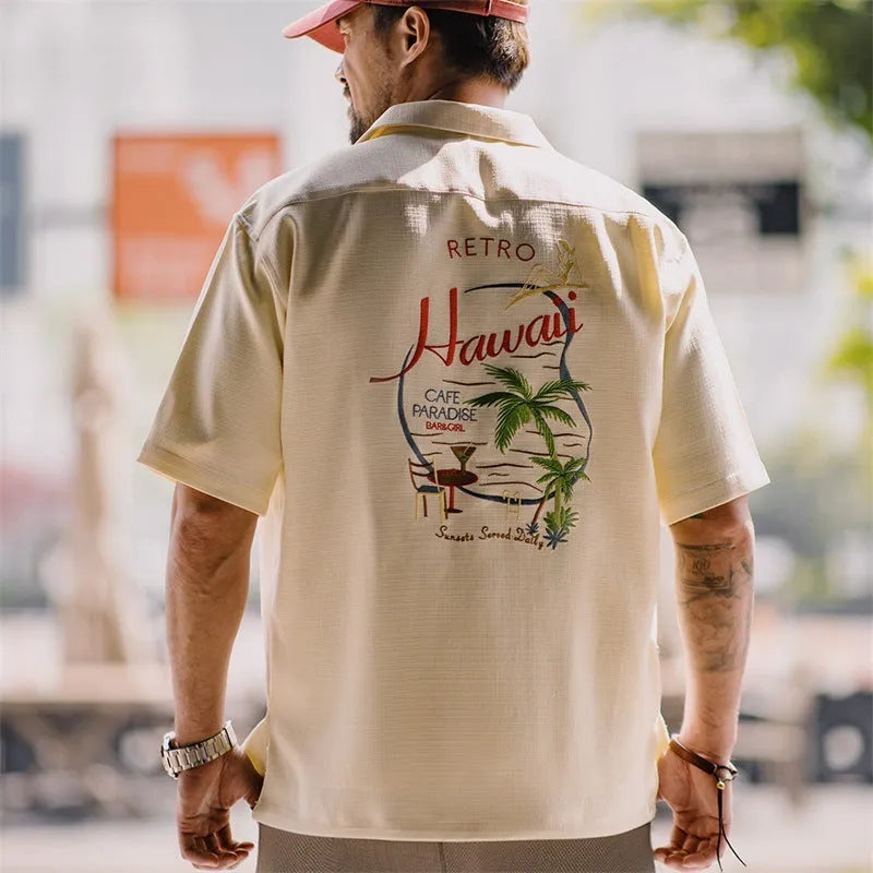 Light apricot men's Cuban collar shirt with bamboo and floral plant pattern.
