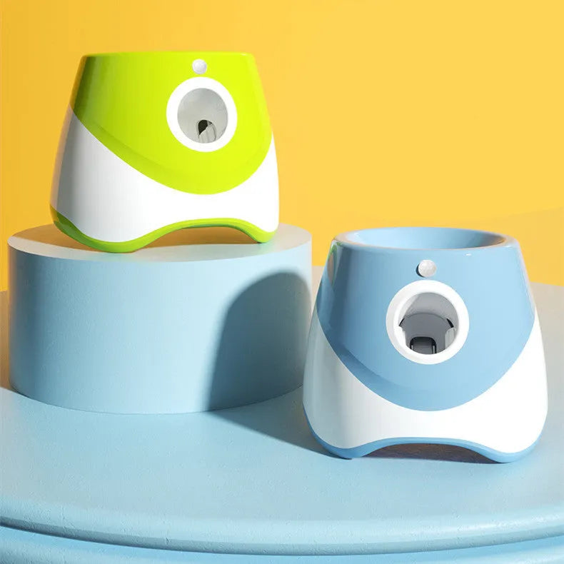 Blue automatic ball thrower with thermal sensor, three tennis balls, and USB charging cable on grass