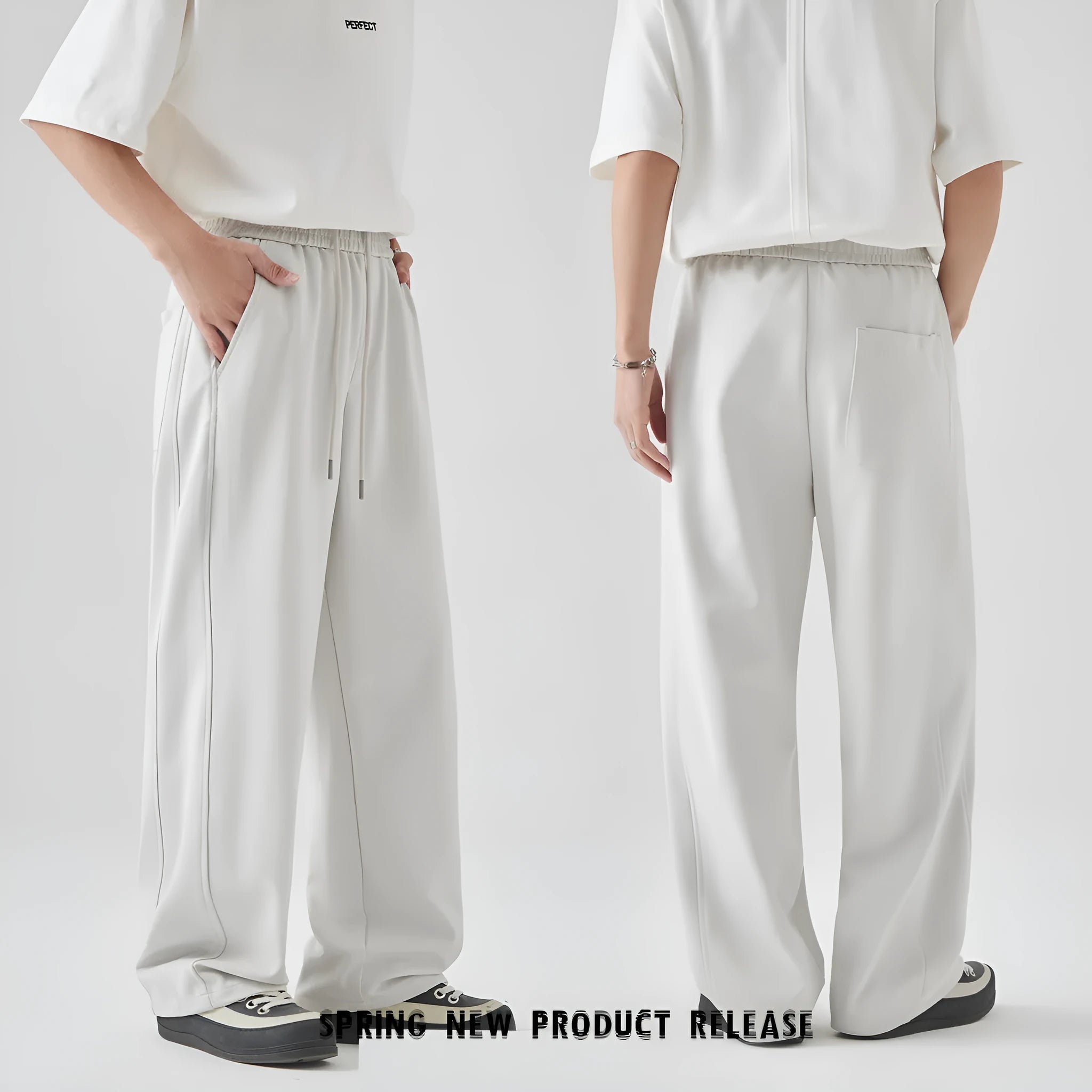 A pair of men's loose-fitting grey casual trousers with a high waist and straight leg on a plain background.