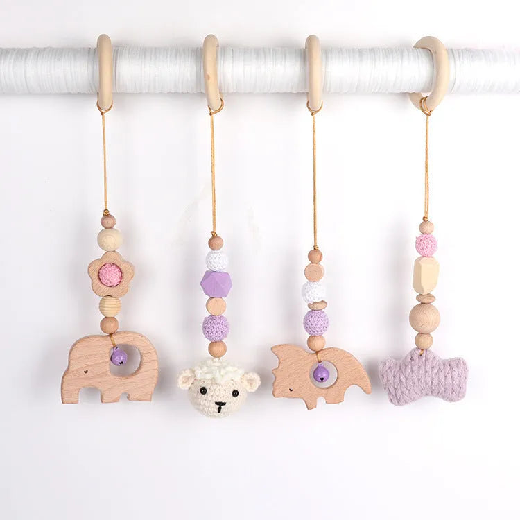Beech wood baby rattle with animal pendants in orange, 28cm length, on white background