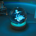 Colorful luminous crystal ball on light wooden base with data cable