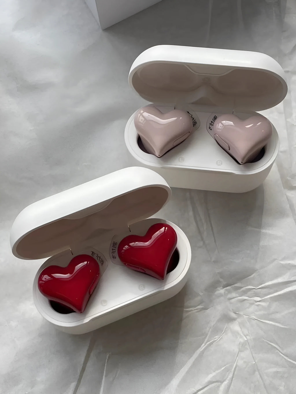 Heart-shaped wireless Bluetooth headphones in red and pink colour options with charging cable
