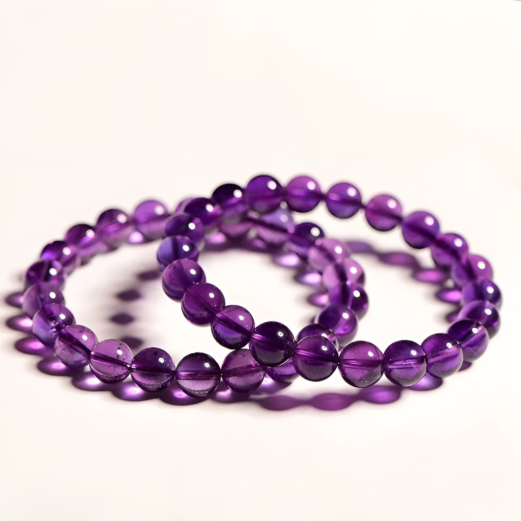 Natural amethyst Uruguay bracelet with scattered polished beads on a white background.