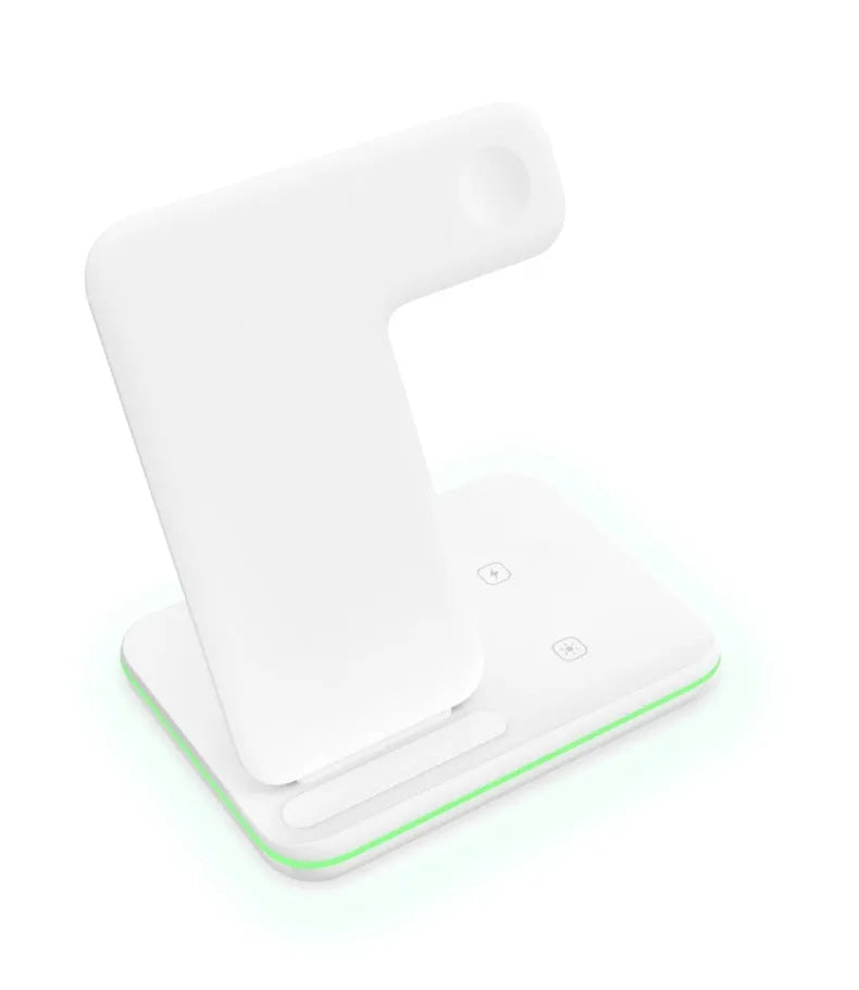 White three-in-one wireless charging stand holding a mobile phone, a smartwatch, and wireless earbuds on a desk.