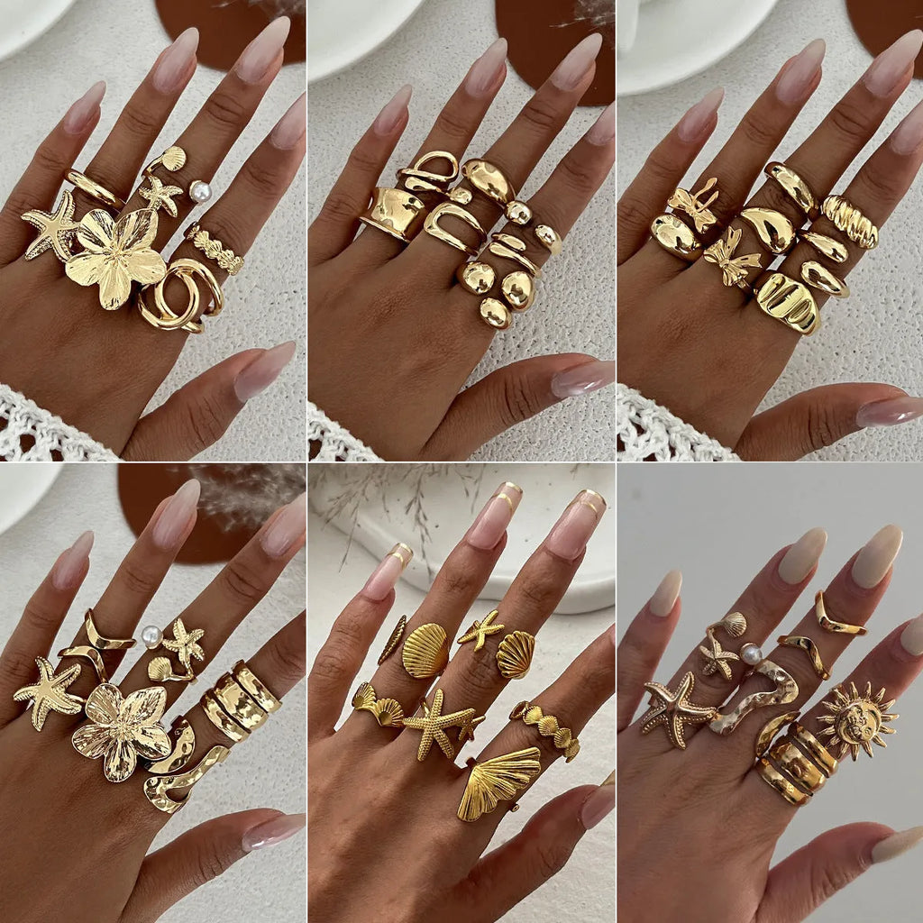 Women's irregular ocean shell ring set with starfish and fan shapes, light gold electroplated metal, 4-piece arrangement