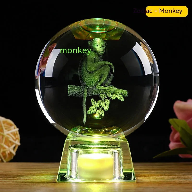 White crystal ball zodiac ornament with luminous electronic base showing Chinese animal designs