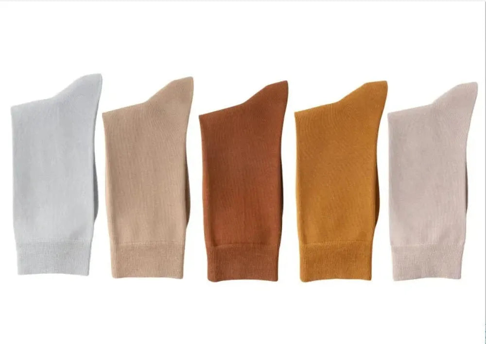 Five pairs of men's solid colour mid-calf socks made from combed cotton, shown in assorted shades.