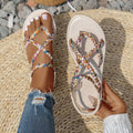 Pair of adult flat sandals with elastic band fastening, cloth upper, and round toe in white.