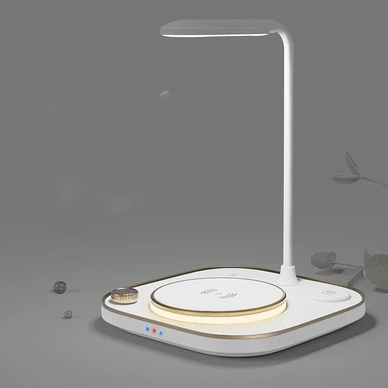 Black wireless magnetic charging station with desk lamp showing three smartphones charging simultaneously