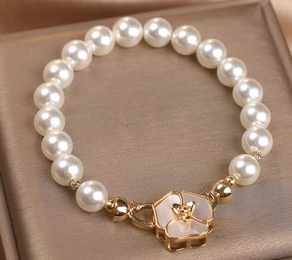 White imitation pearl bracelet with floral French-style design on display for women