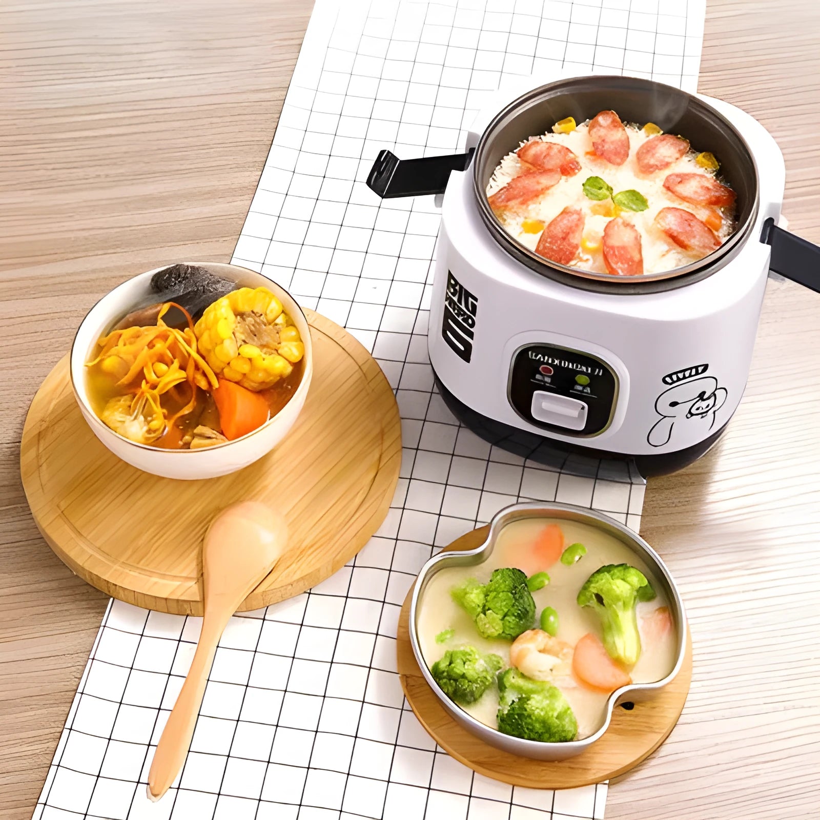 Compact round miniature rice cooker with steaming tray in blue, shown with non-stick liner and mechanical control panel.
