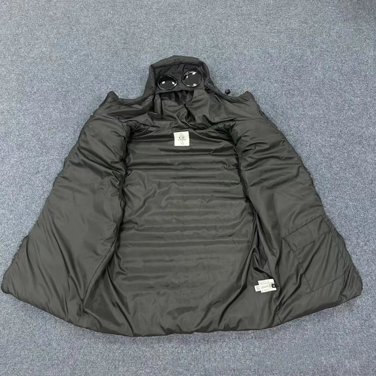 Men's loose hooded cotton vest jacket in black, side view, showing hood and zip closure