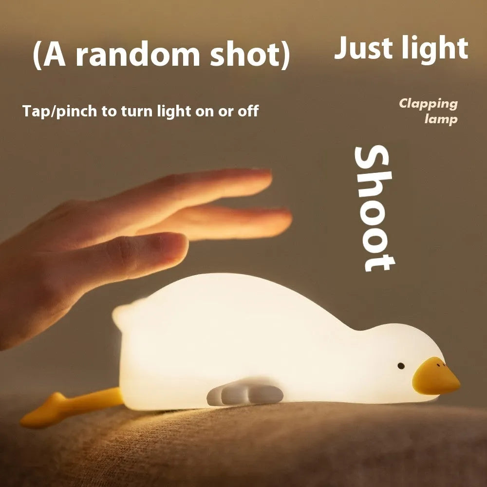 Big White Geese night light with warm white glow and silicone exterior on bedside table