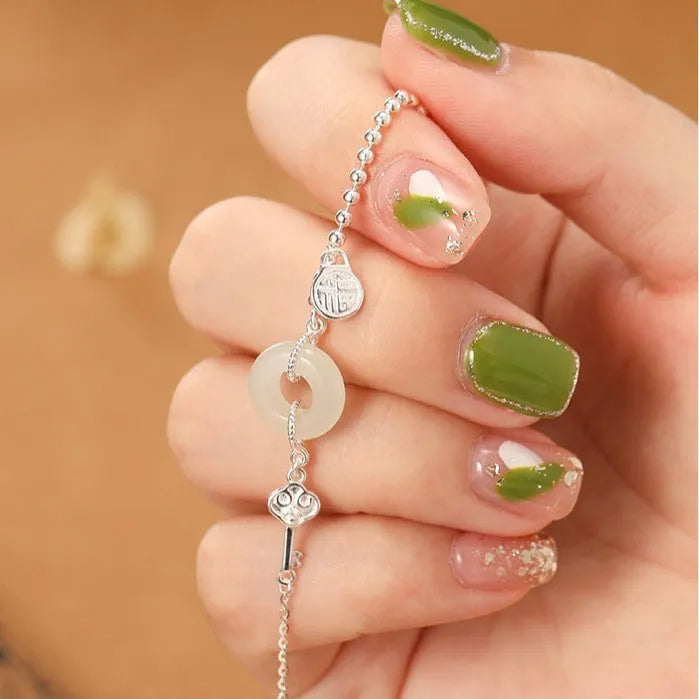 Women's silver bracelet with a geometric Hetian jade Wishful Blessings charm on a white background.