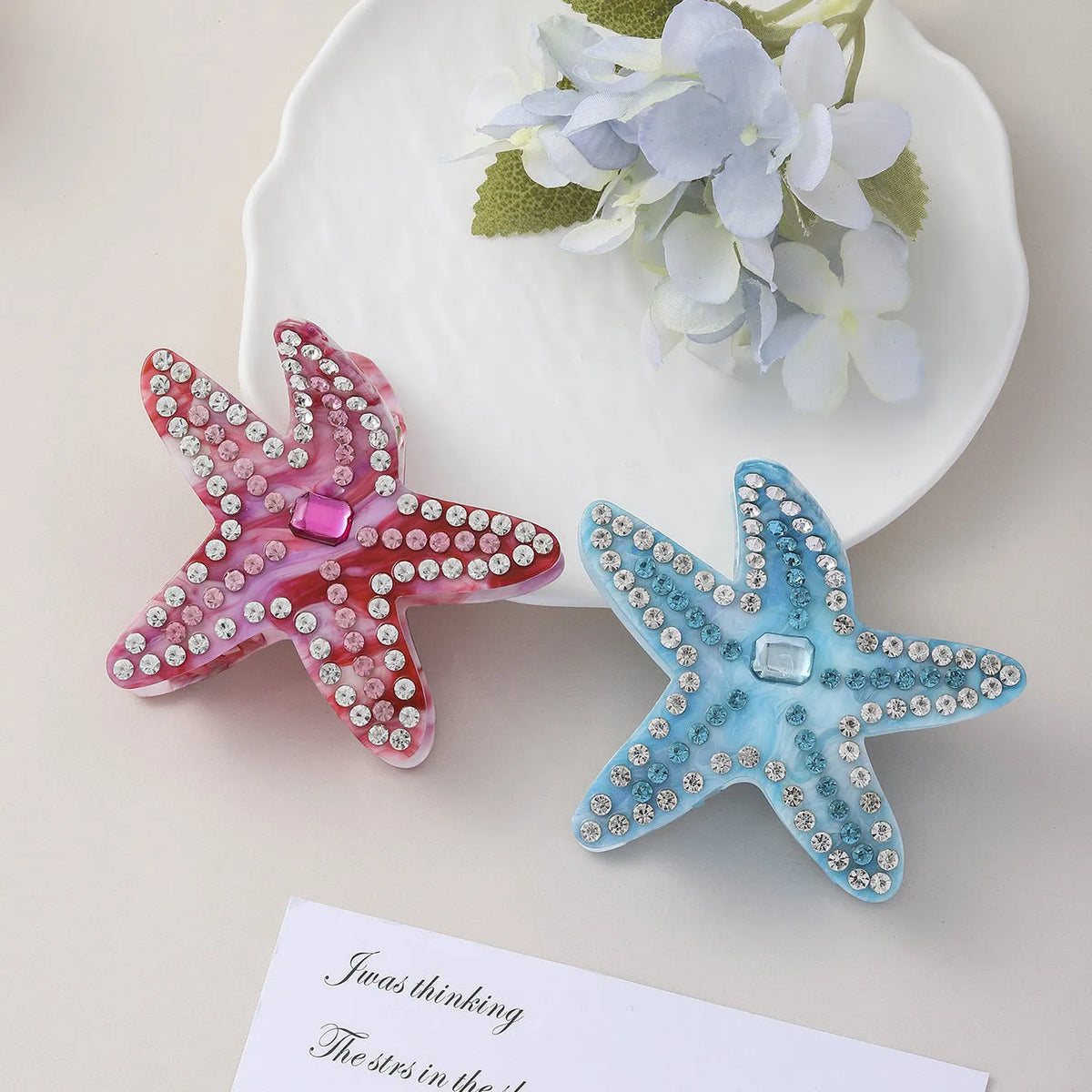 Blue acrylic starfish hairpin with diamond-encrusted surface on white background