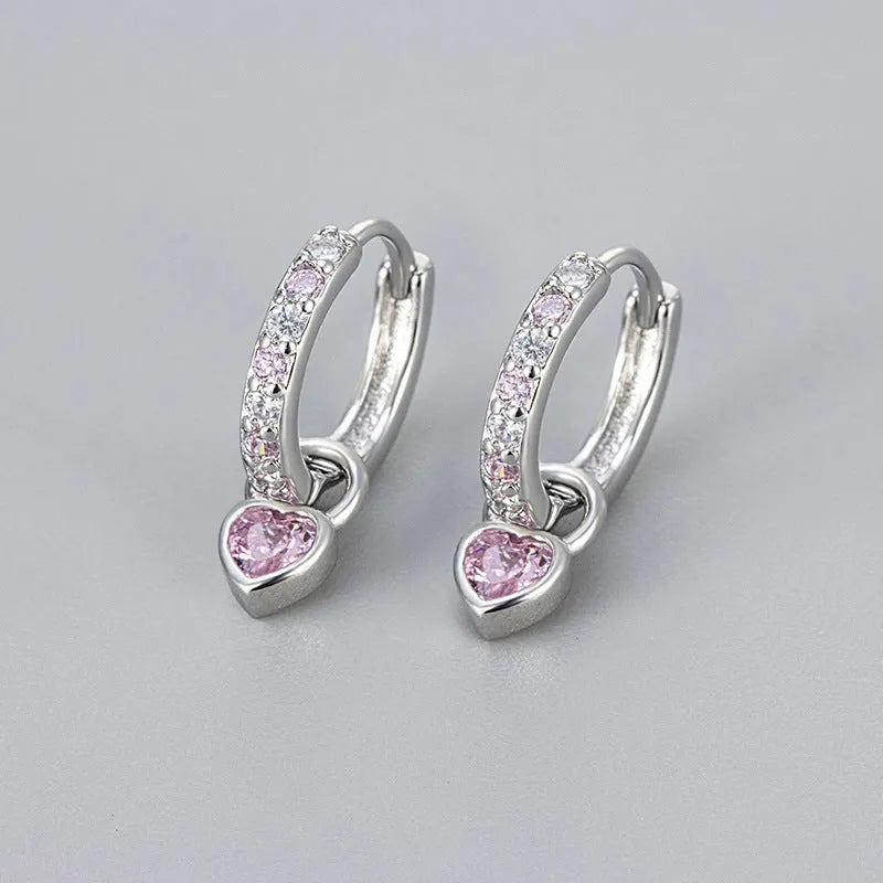 Gold colour heart-shaped clip earring with a central blue zircon stone on a white background.
