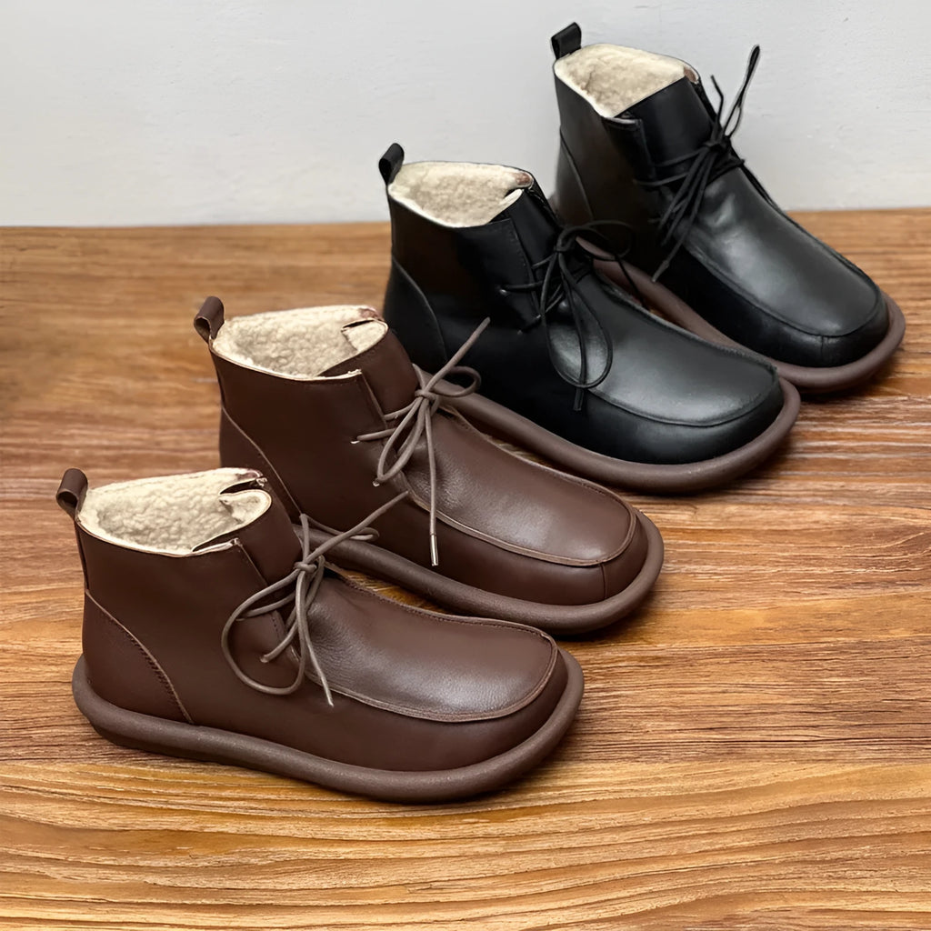 Women's black cowhide boots with a flat heel and round toe, featuring a velvet lining.