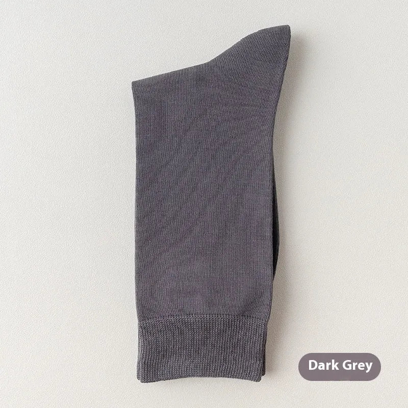 Five pairs of men's solid colour mid-calf socks made from combed cotton, shown in assorted shades.