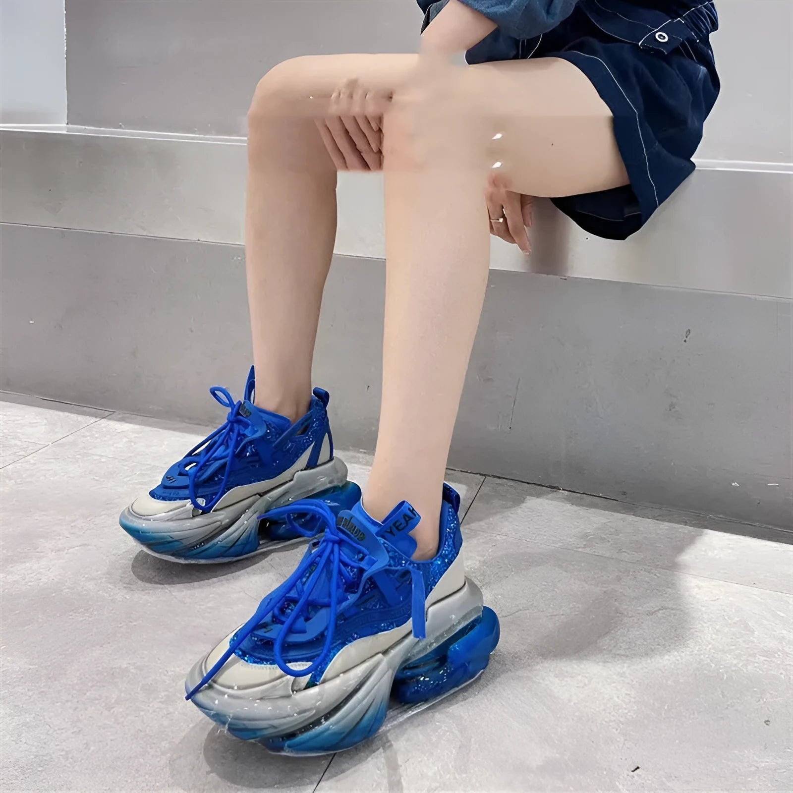 Women's black casual sports shoes with a thick translucent jelly rubber sole and leather upper with cross tie laces.