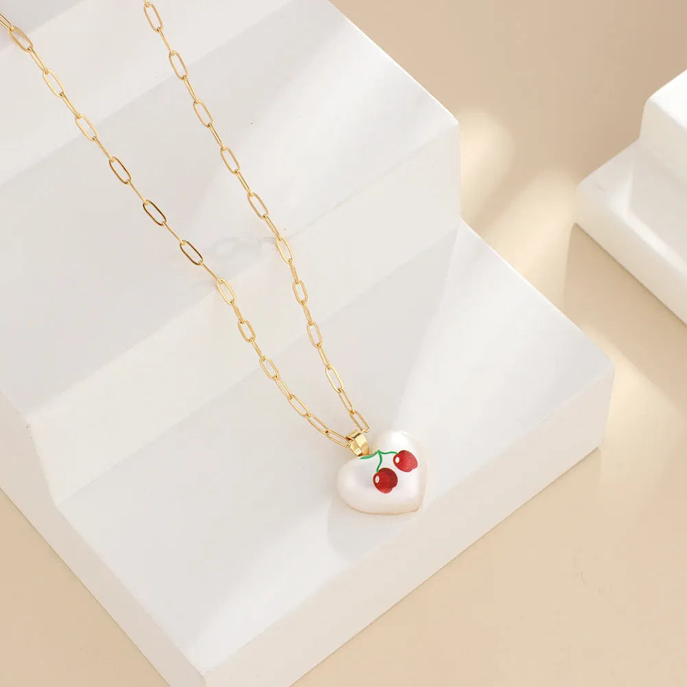 Heart-shaped necklace with geometric chain and a detailed fruit pendant charm, adjustable from 21cm to 50cm.