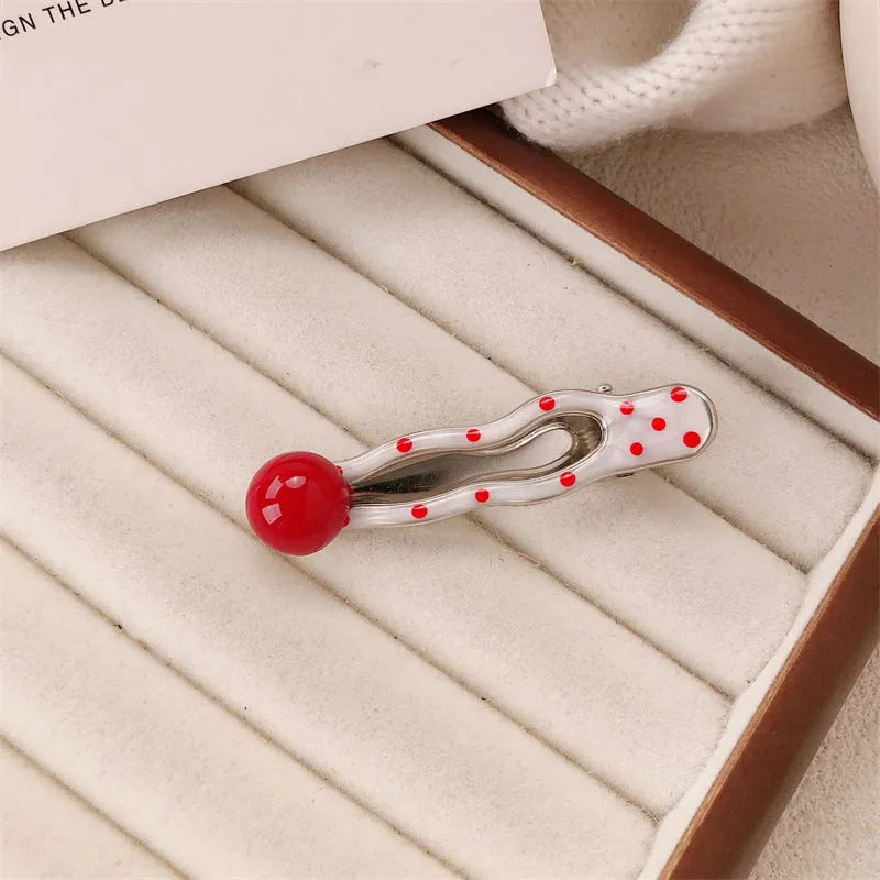 Red love heart-shaped plastic hair clip with retro dots and a willow leaf silhouette on a white background.