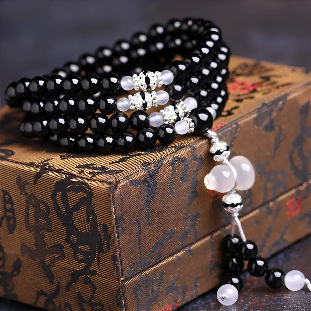 Natural red and black agate stone beaded bracelet with 108 geometric beads on a wrist.