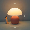 Cream ceramic mushroom table lamp with USB power cord on a bedside table, available in yellow
