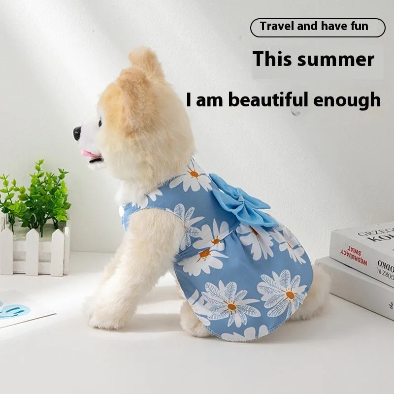 A dog or cat wearing a thin orange princess dress with a large floral butterfly knot bow.