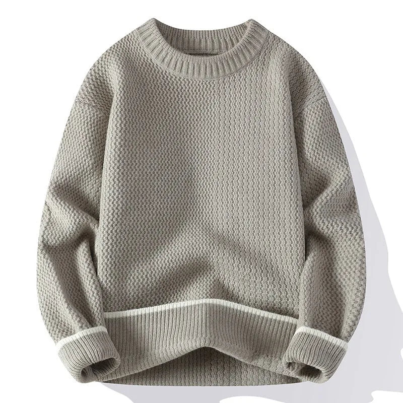 Man wearing a loose-fit grey casual pullover sweater with a round neck and long sleeves.