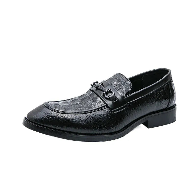 Men's black slip-on formal shoes with pointed toe and belt buckle detail on a light background