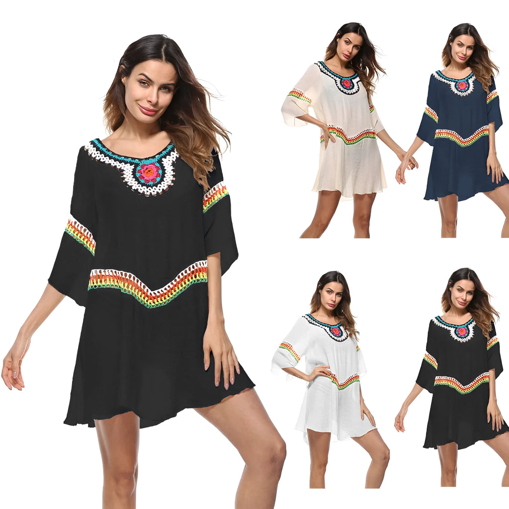 Woman wearing a crocheted white sun protection beach cover-up by the water.