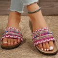 Pair of ethnic style platform slippers with rivet details, featuring linen upper and PVC sole, on a neutral background