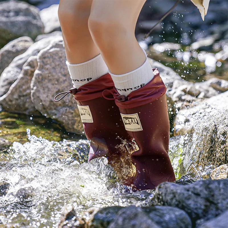 Pair of solid colour high tube PVC rain boots with a low heel on a non-slip sole.