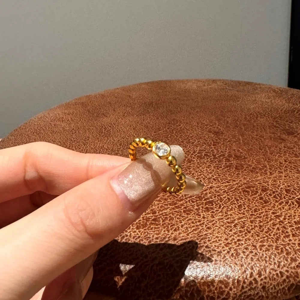 S925 sterling silver ring for women with gold wave bead design and geometric polka-dot pattern on white background