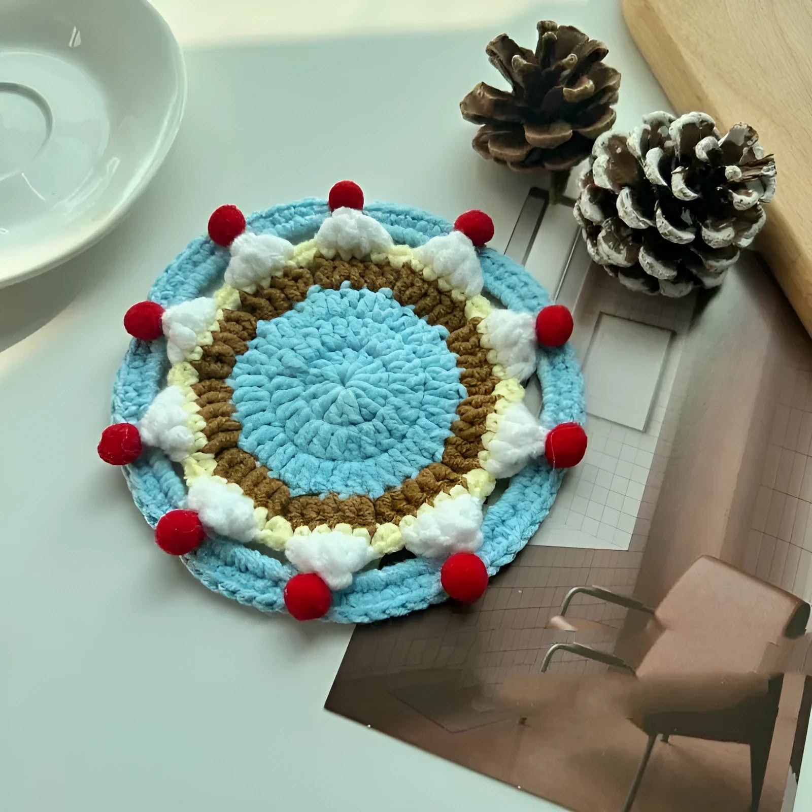 Round 9cm grey felted wool coaster next to its drawstring storage pouch.