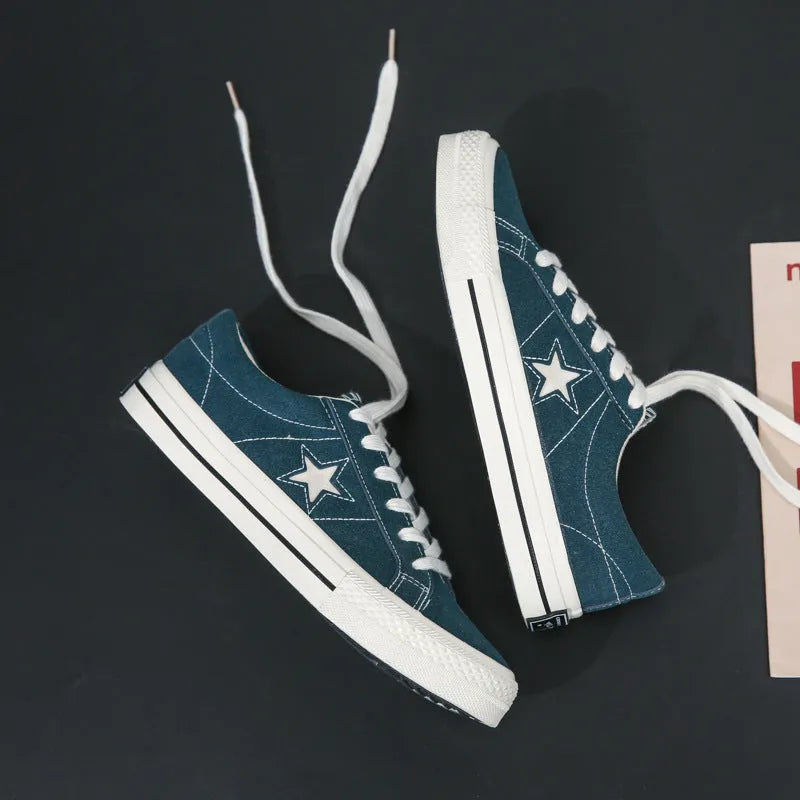Low top board shoes with cross straps and leather stitching, available in green, black, light blue, grey, ink blue