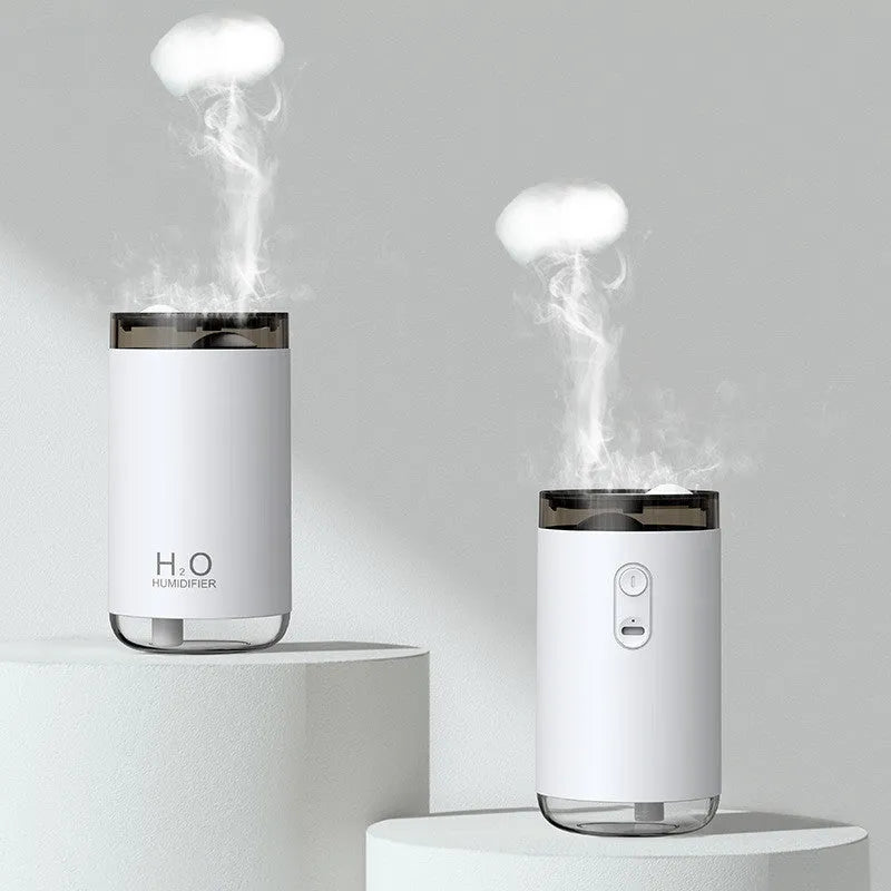 White USB humidifier emitting jellyfish-shaped smoke ring mist with warm night light glow on a desk.