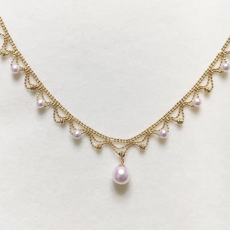 Aurora Japanese 18k gold lace pearl necklace with round sea pearl and gold finish on display