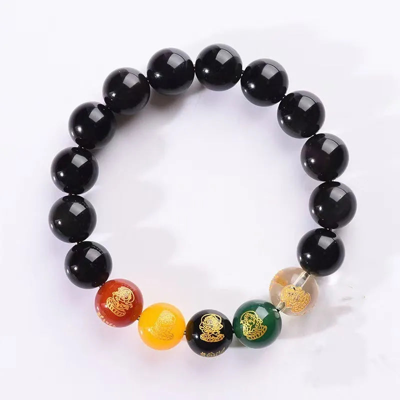 Close-up of a polished crystal bracelet with rainbow eye obsidian beads in a single circle design on a wrist.