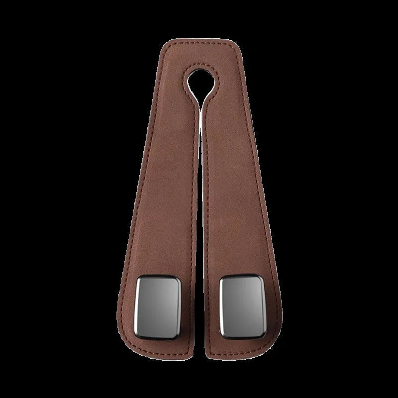 Black suede and metal car seat hook organiser hanging on a car headrest.