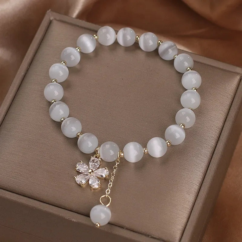 Women's white cat's eye bracelet with flower tassel and safety buckle pendant